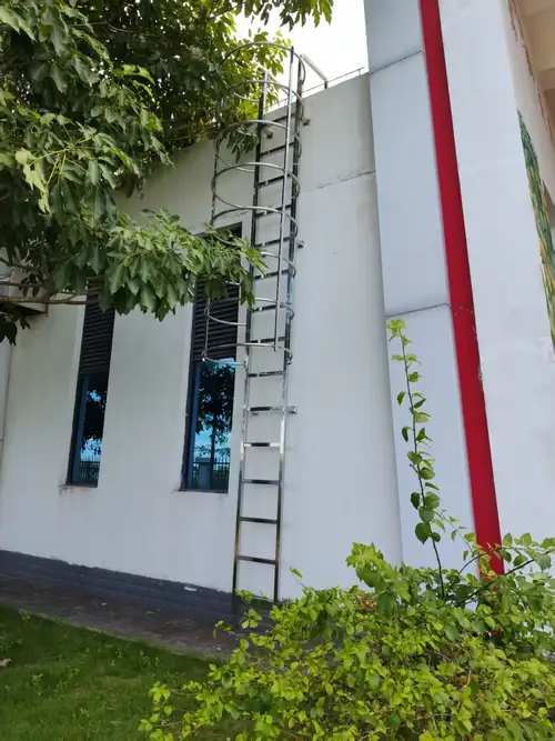 Escalera de acero inoxidable con jaula de protección